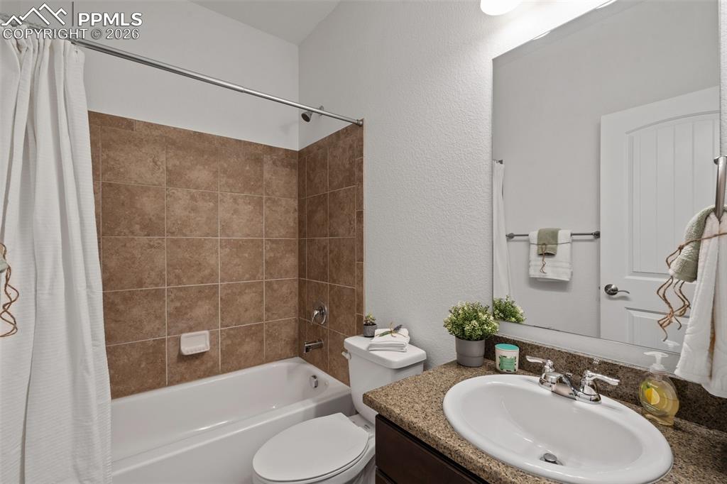 Image 26 of 48: Full bath featuring shower / tub combo, vanity, and a textured wall