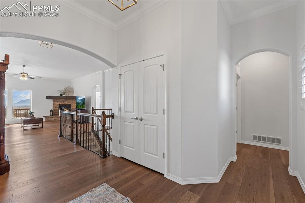 Image 6 of 48: Hallway featuring arched walkways, dark wood-type flooring, ornamental mold