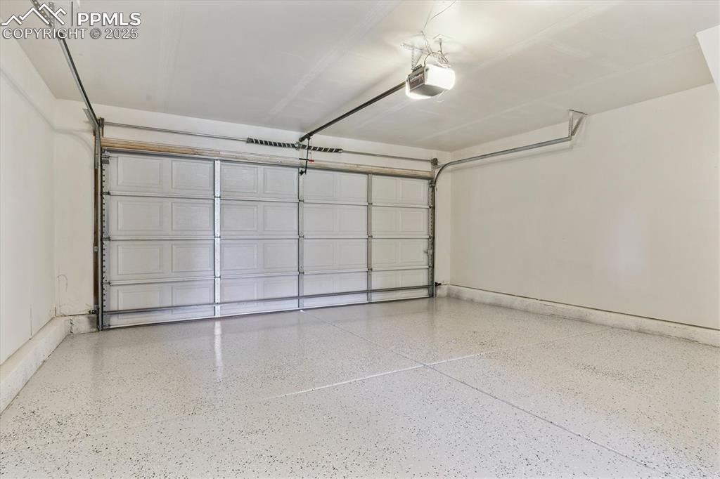 Image 13 of 14: Garage featuring a garage door opener