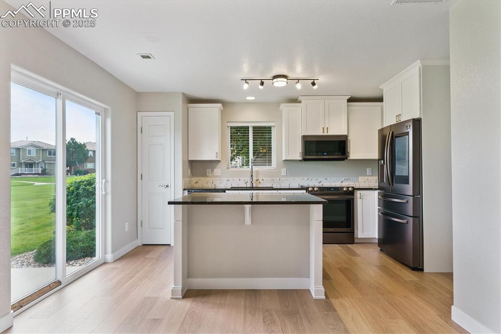 Image 2 of 14: Kitchen featuring appliances with stainless steel finishes, dark countertop