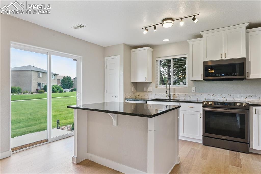Image 6 of 14: Kitchen featuring appliances with stainless steel finishes, a kitchen islan