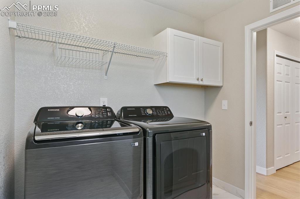 Image 8 of 14: Laundry room featuring washer and clothes dryer, cabinet space, and light w