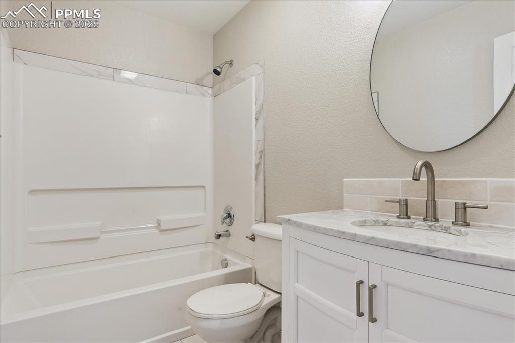 Image 9 of 14: Full bath featuring a textured wall, bathing tub / shower combination, and