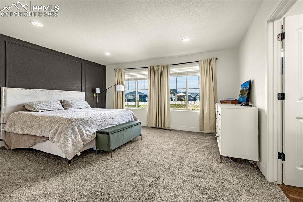 Image 12 of 32: Bedroom with light carpet and recessed lighting