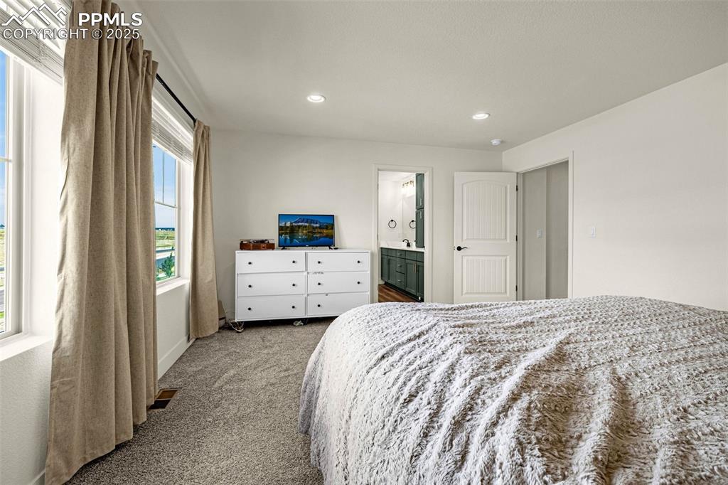 Image 14 of 32: Carpeted bedroom with ensuite bathroom and recessed lighting