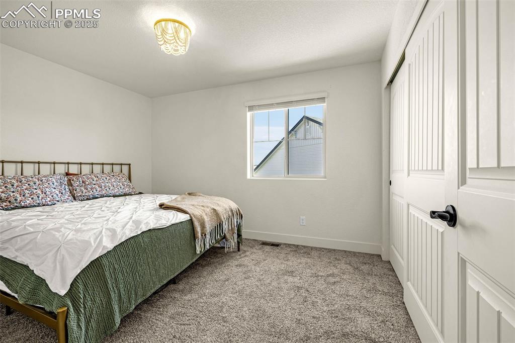 Image 22 of 32: Carpeted bedroom featuring a closet and a textured ceiling