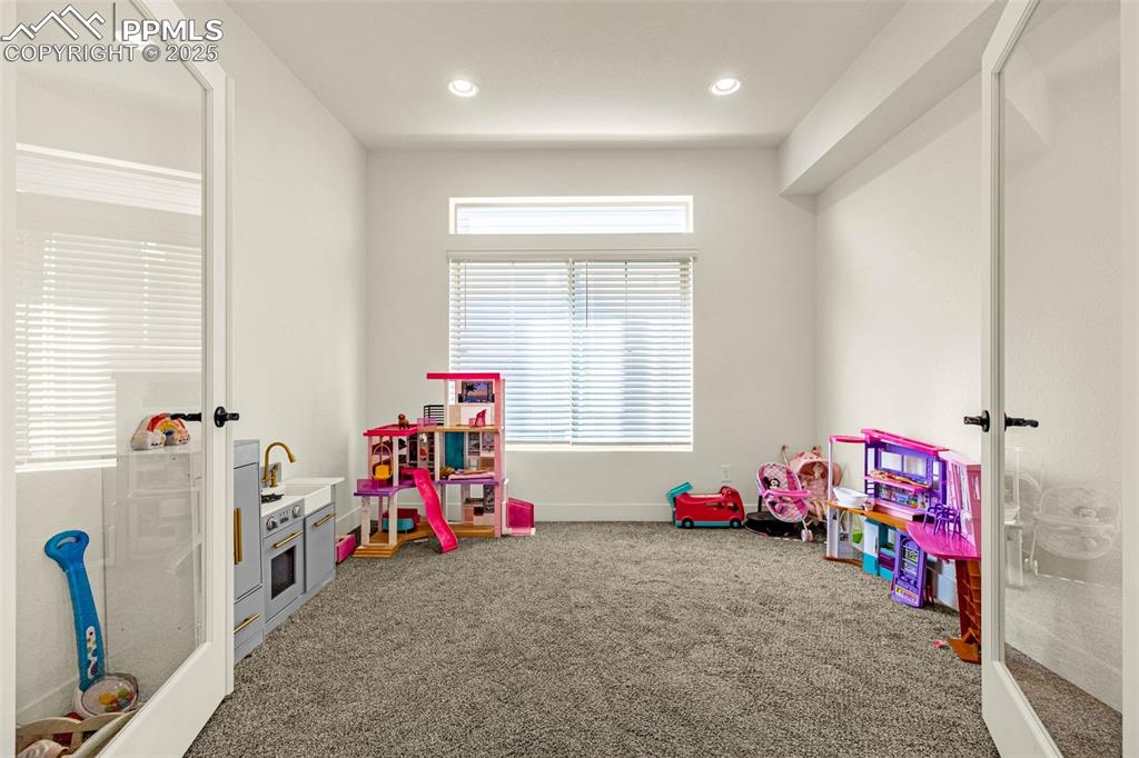 Image 24 of 32: Rec room with carpet floors, recessed lighting, and french doors