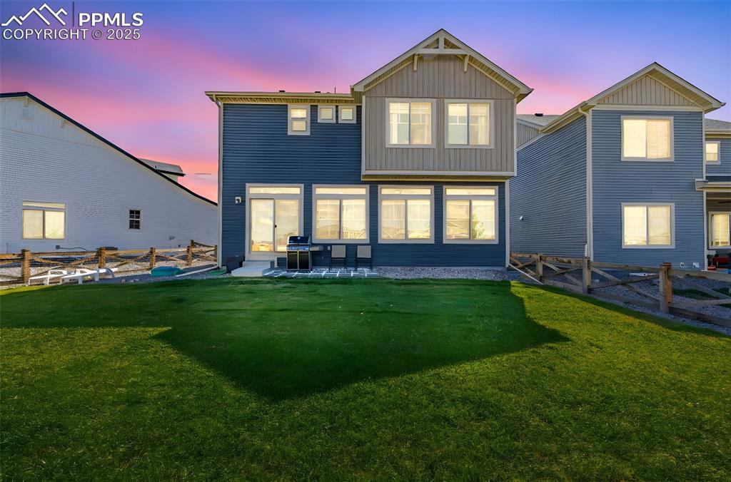 Image 26 of 32: Back of property at dusk with a fenced backyard, a patio area, and board an
