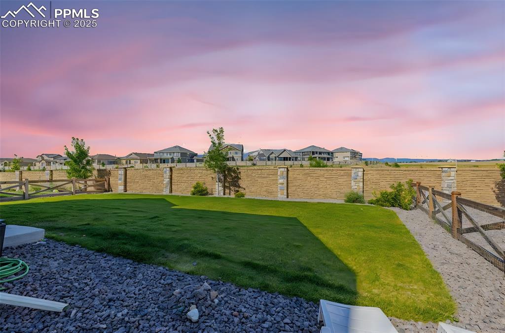 Image 28 of 32: Yard at dusk featuring a fenced backyard and a residential view