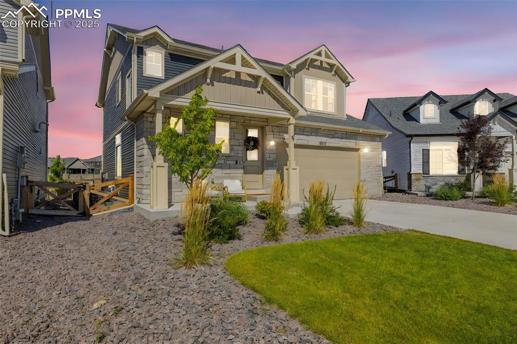 Image 32 of 32: Craftsman-style house featuring board and batten siding, stone siding, a ga