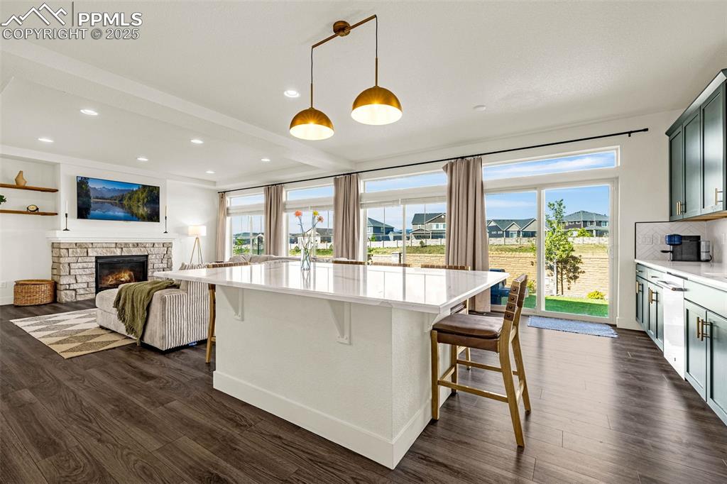 Image 9 of 32: Kitchen with a kitchen bar, pendant lighting, dark wood-style floors, a kit