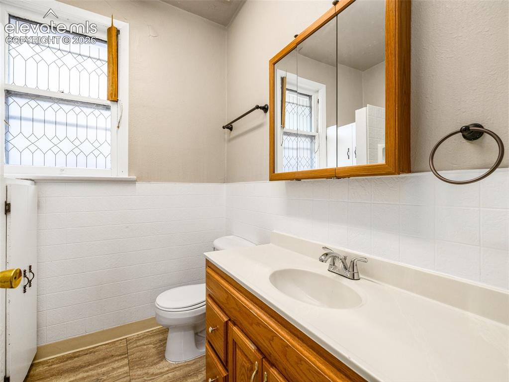 Image 11 of 22: Bathroom featuring a wood-finish vanity with a white countertop, an integra