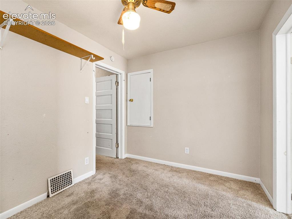 Image 14 of 22: Neutral wall paint, ceiling fan with light fixture, carpet flooring, and a 
