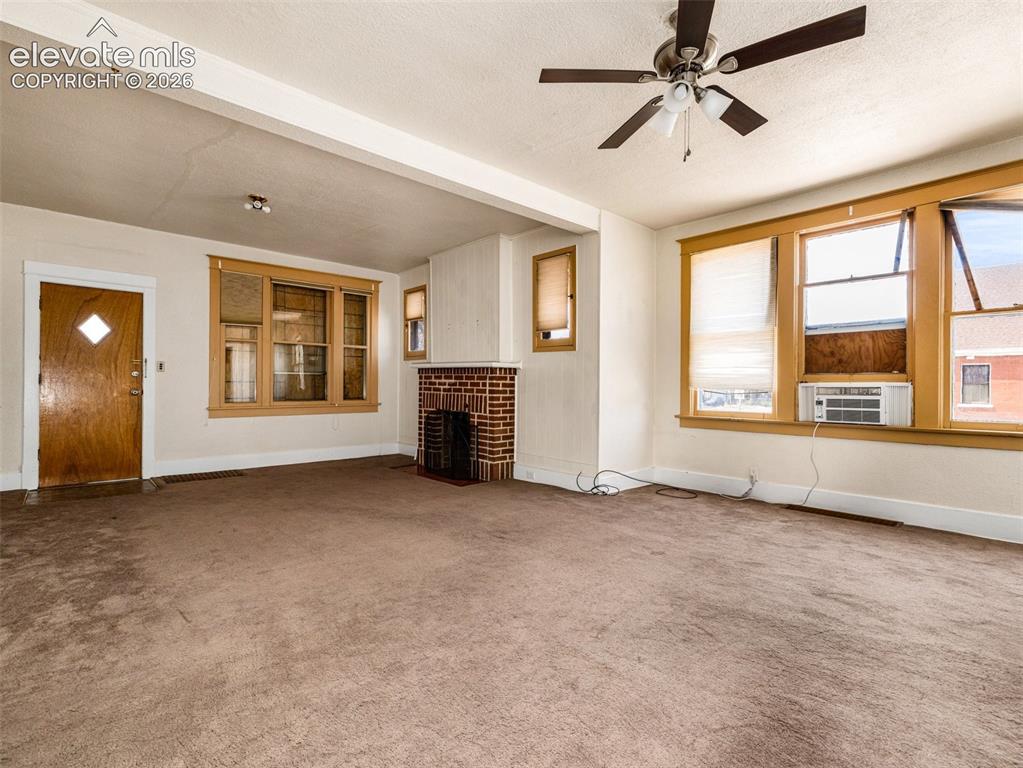 Image 6 of 22: Spacious living area with neutral carpet flooring, ceiling fan with integra
