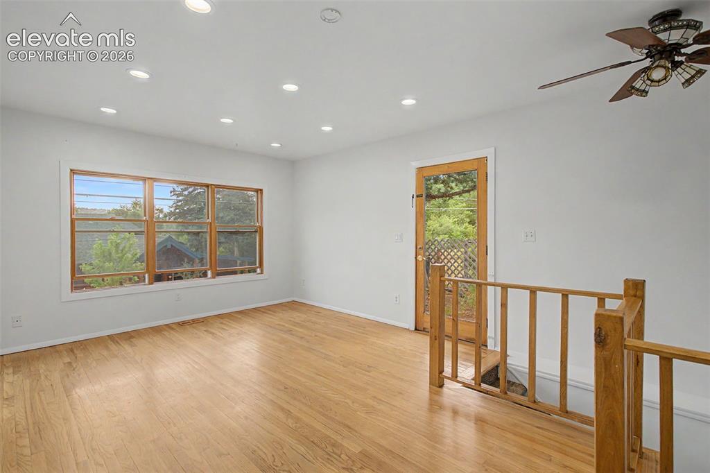 Image 10 of 27: Spacious room featuring wood-finish flooring, recessed lighting, and a mult