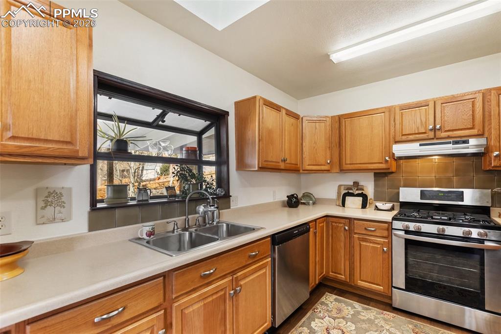 Image 16 of 37: Dining area with skylights and ceiling fan. 