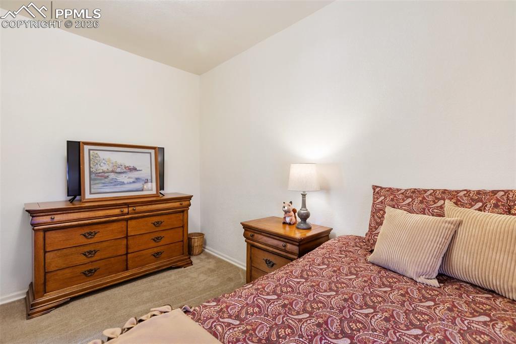 Image 22 of 37: Spacious bedroom offers room for bed, sitting area, dresser and nightstands