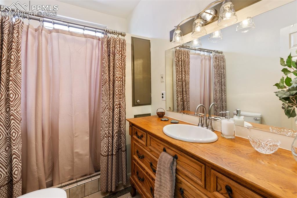 Image 26 of 37: Full bath with old world vanity and sink.