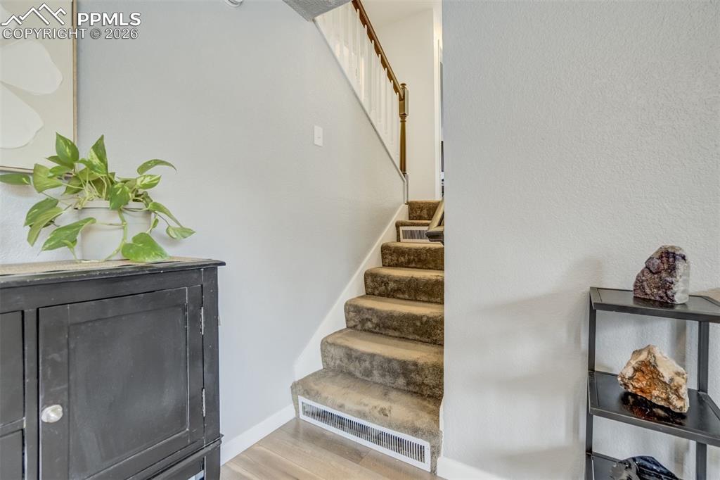 Image 14 of 44: Stairs featuring wood finished floors and baseboards
