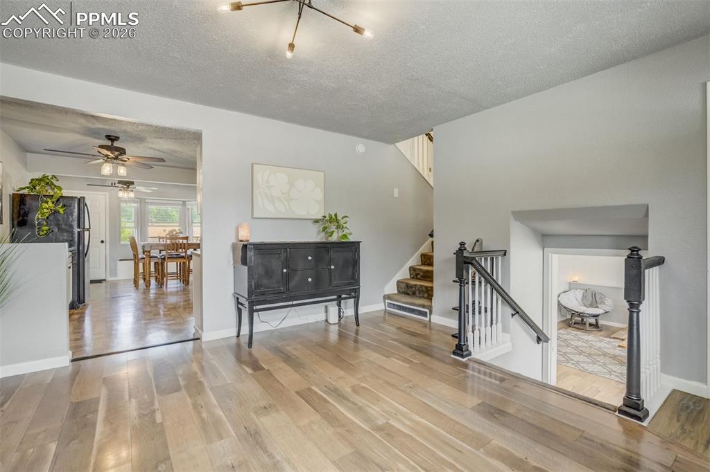 Image 5 of 44: Living room with a textured ceiling, light wood-style floors, and ceiling f