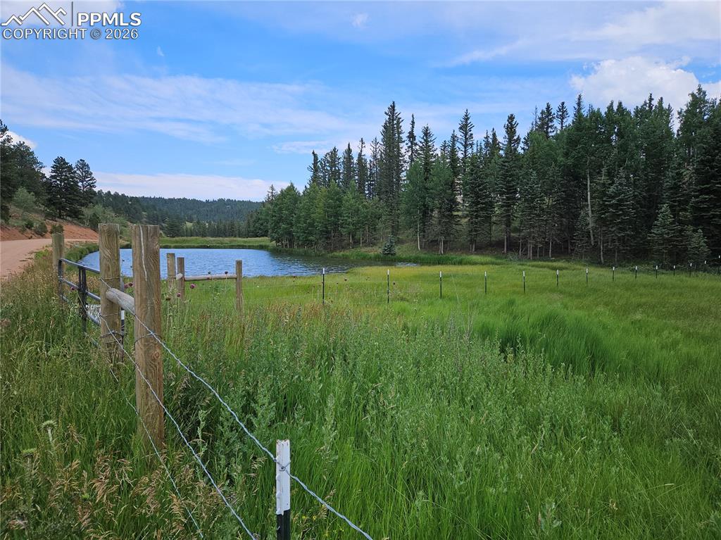 Image 2 of 47: Front of Property by Road with View of Adjoining Private HOA Community Fish