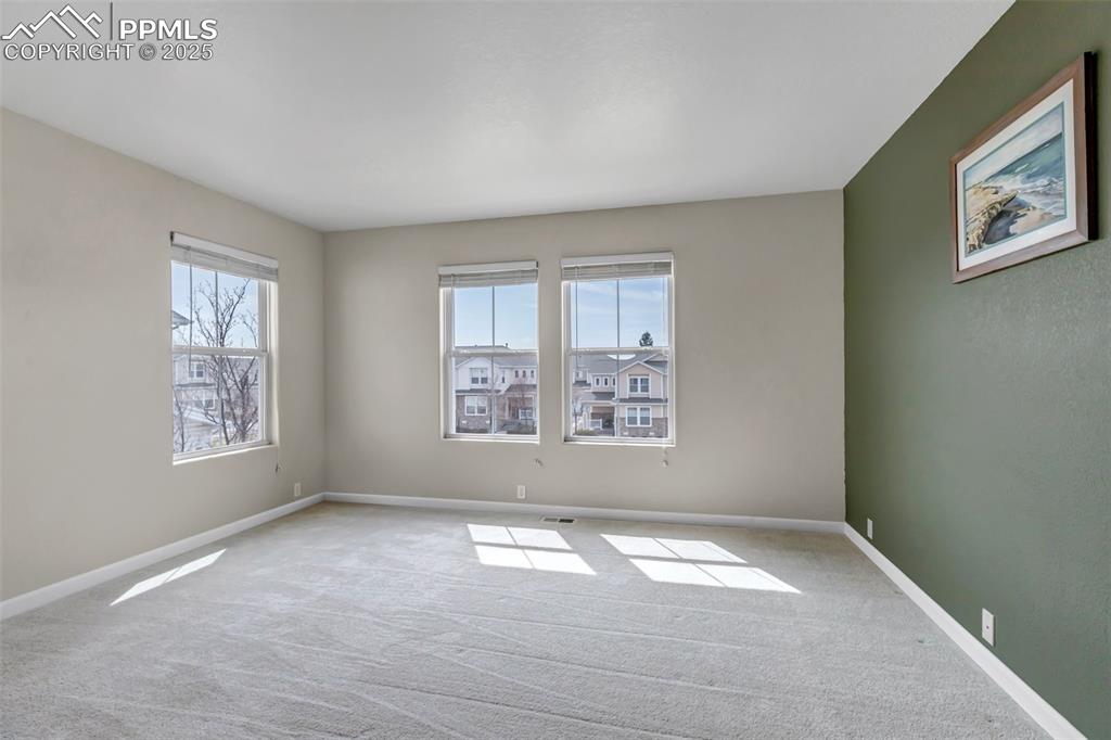 Image 15 of 46: Empty room featuring healthy amount of natural light and carpet