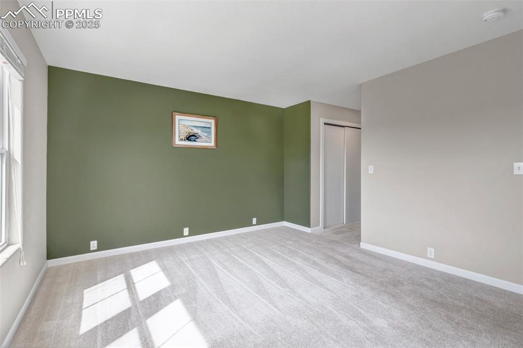 Image 16 of 46: Empty room featuring light colored carpet and a smoke detector