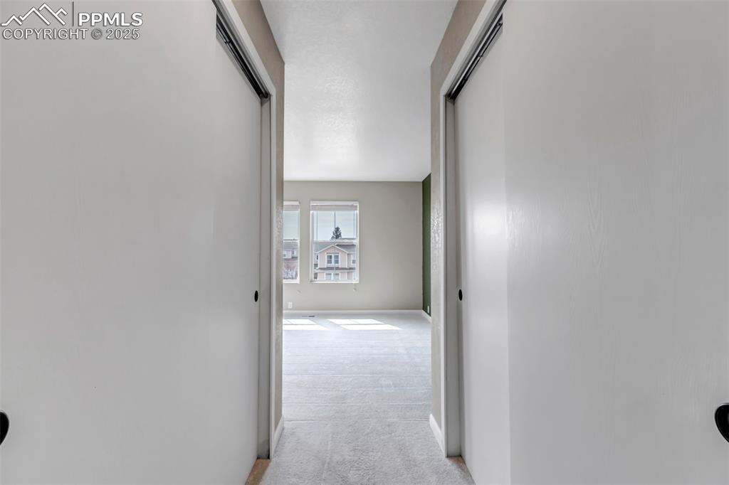 Image 17 of 46: Hallway featuring light colored carpet and baseboards