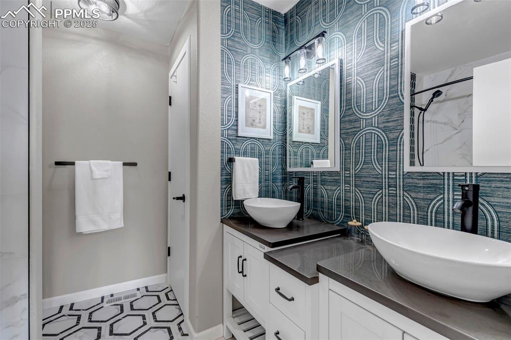 Image 18 of 46: Bathroom with double vanity and a shower