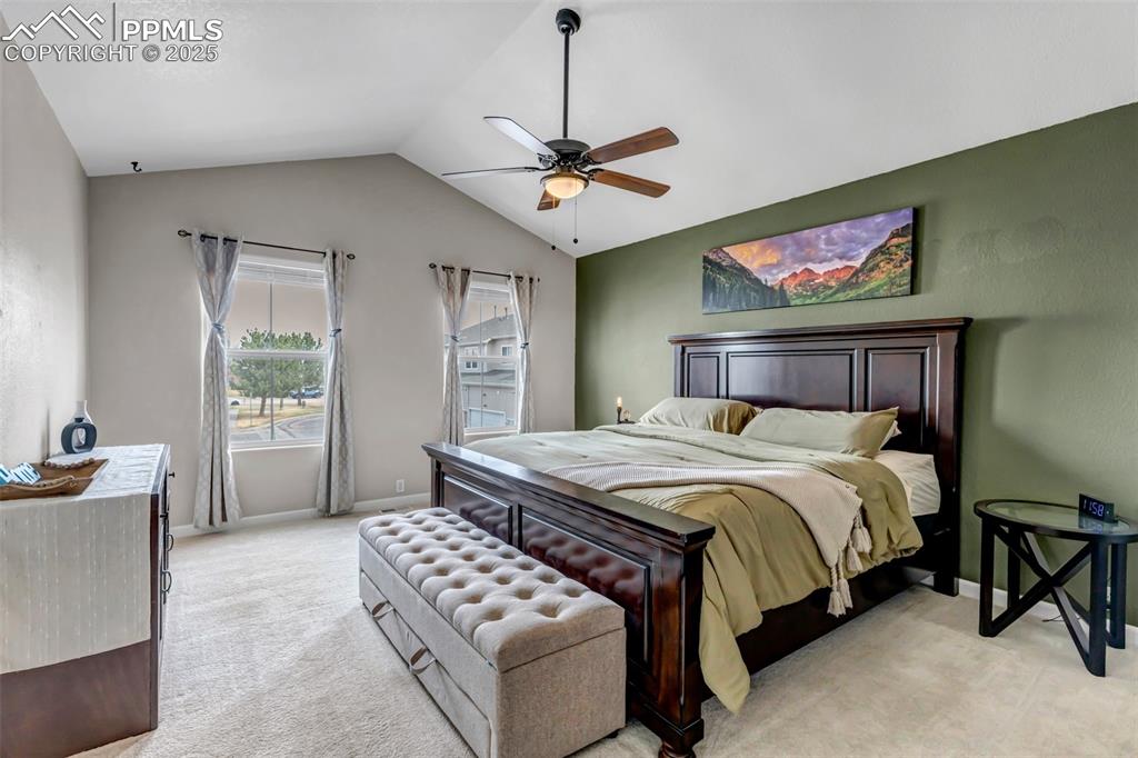 Image 22 of 46: Bedroom featuring light carpet, vaulted ceiling, and a ceiling fan