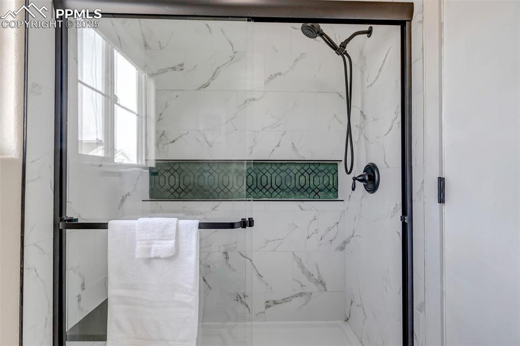 Image 28 of 46: Bathroom with a marble finish shower