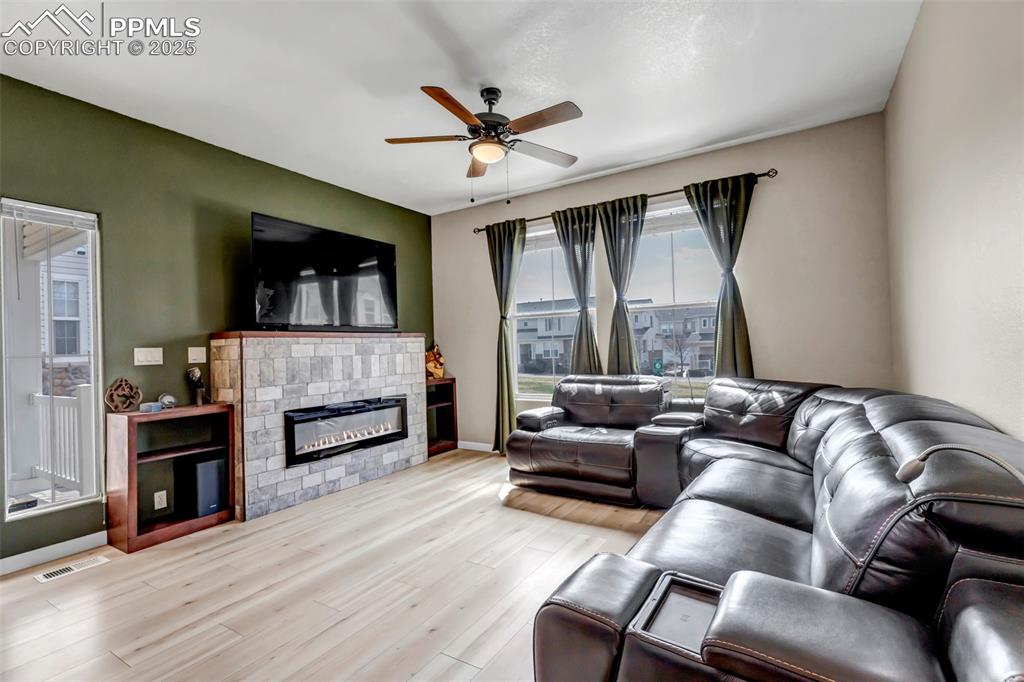 Image 31 of 46: Living room with ceiling fan, wood finished floors, and a glass covered fir