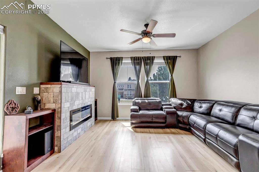 Image 32 of 46: Living area featuring light wood-type flooring, a ceiling fan, and a tiled