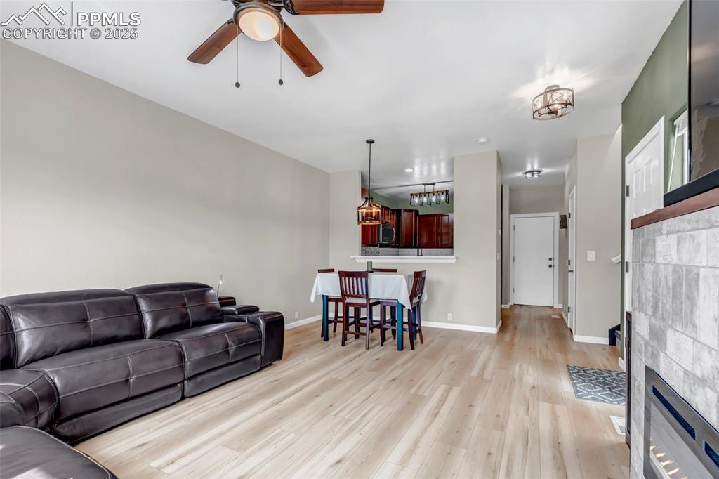 Image 34 of 46: Living room featuring a tile fireplace, light wood-type flooring, and a cei