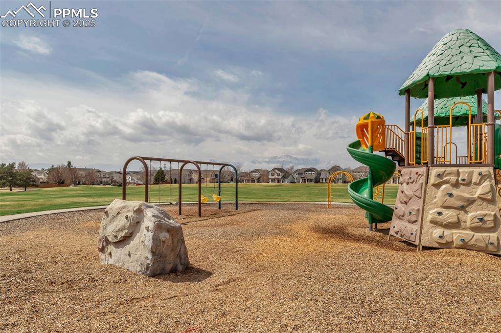 Image 45 of 46: Community playground with a residential view and a lawn