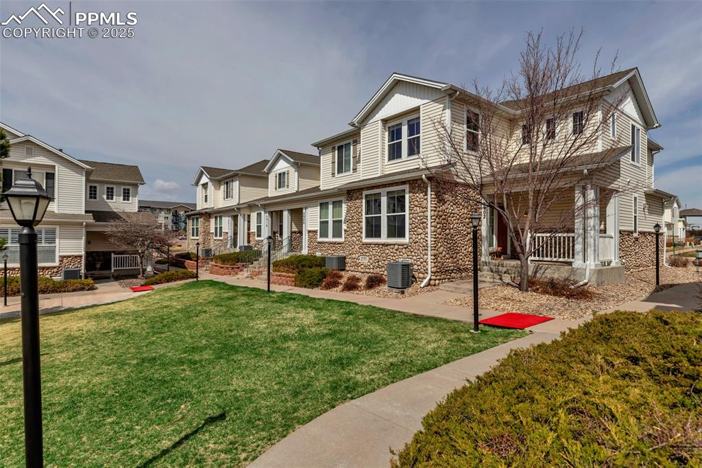 Image 9 of 46: View of front of home with stone siding, a front yard, covered porch, and a