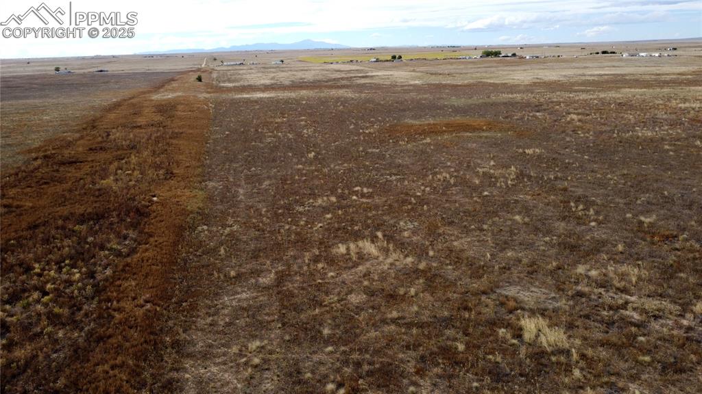 Image 12 of 21: Aerial view of sparsely populated area with a mountainous background