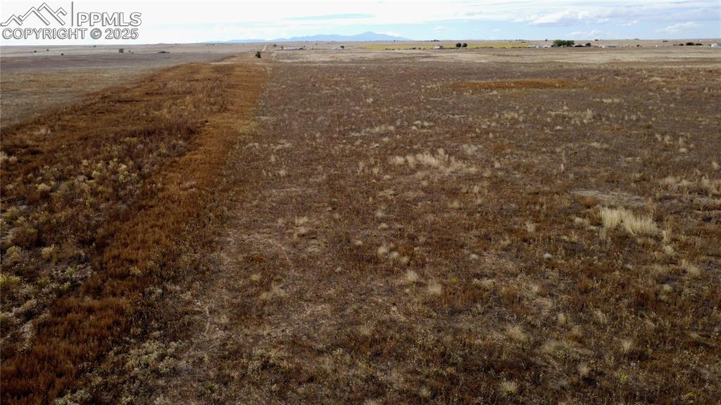 Image 14 of 21: Aerial view of sparsely populated area featuring a mountain backdrop