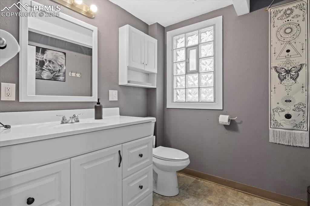 Image 11 of 14: 1st Bathroom with a textured wall and vanity