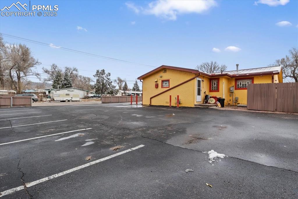 Image 2 of 14: View of front facade with uncovered parking and stucco siding