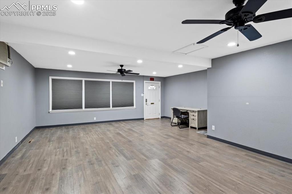 Image 4 of 14: First Unit room featuring a ceiling fan, recessed lighting, and wood finish
