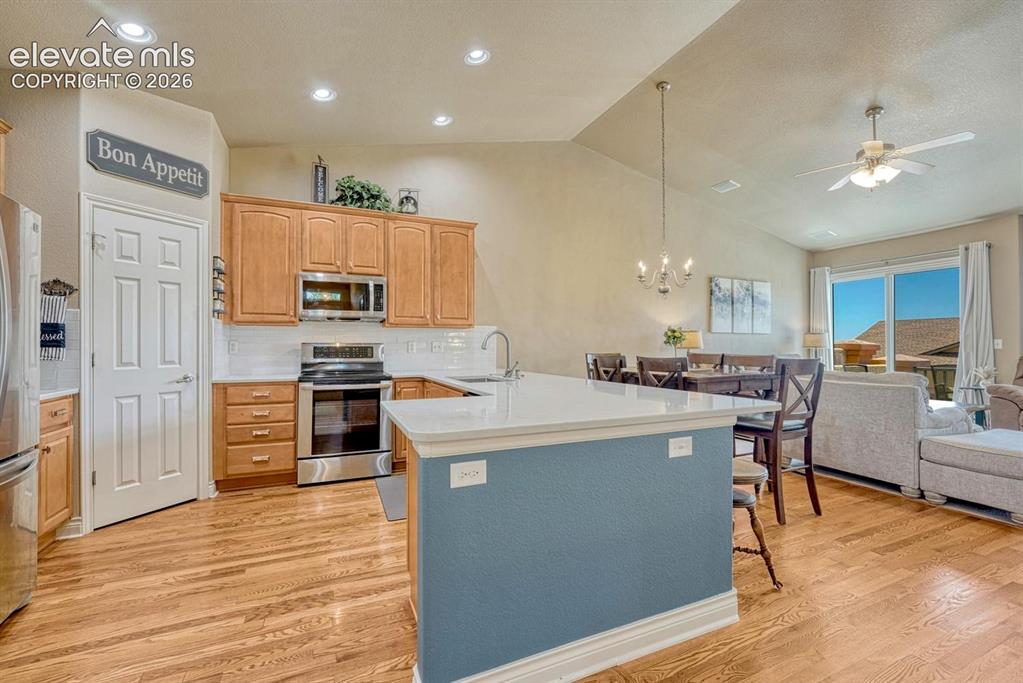 Image 10 of 41: Open-concept kitchen featuring wood-finish flooring, light wood cabinetry,