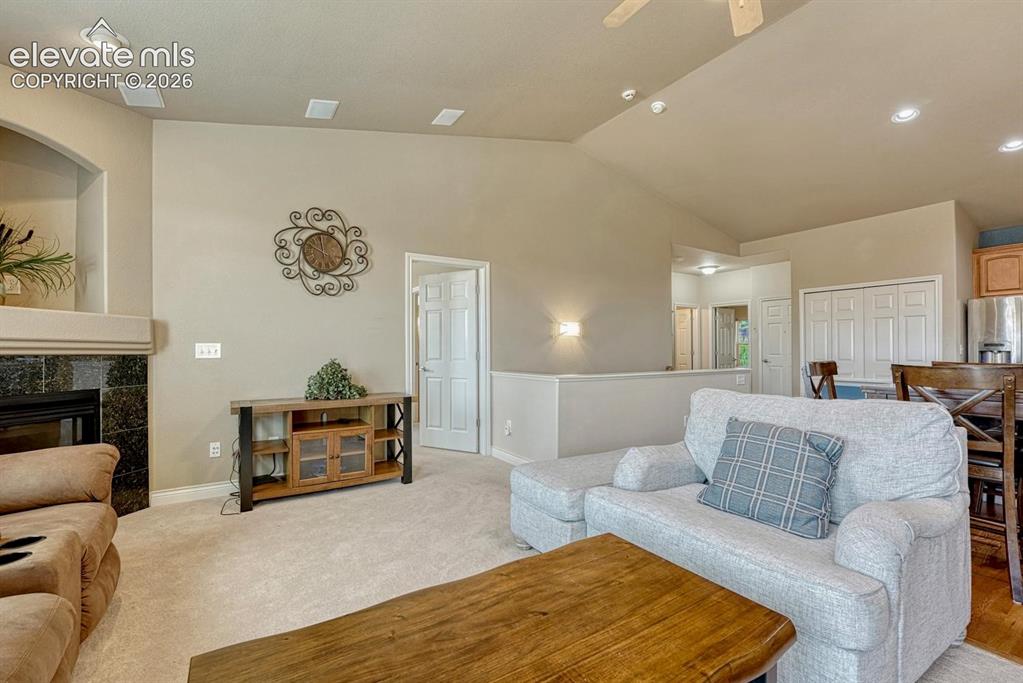 Image 15 of 41: Living space featuring vaulted ceilings, recessed lighting, a fireplace wit