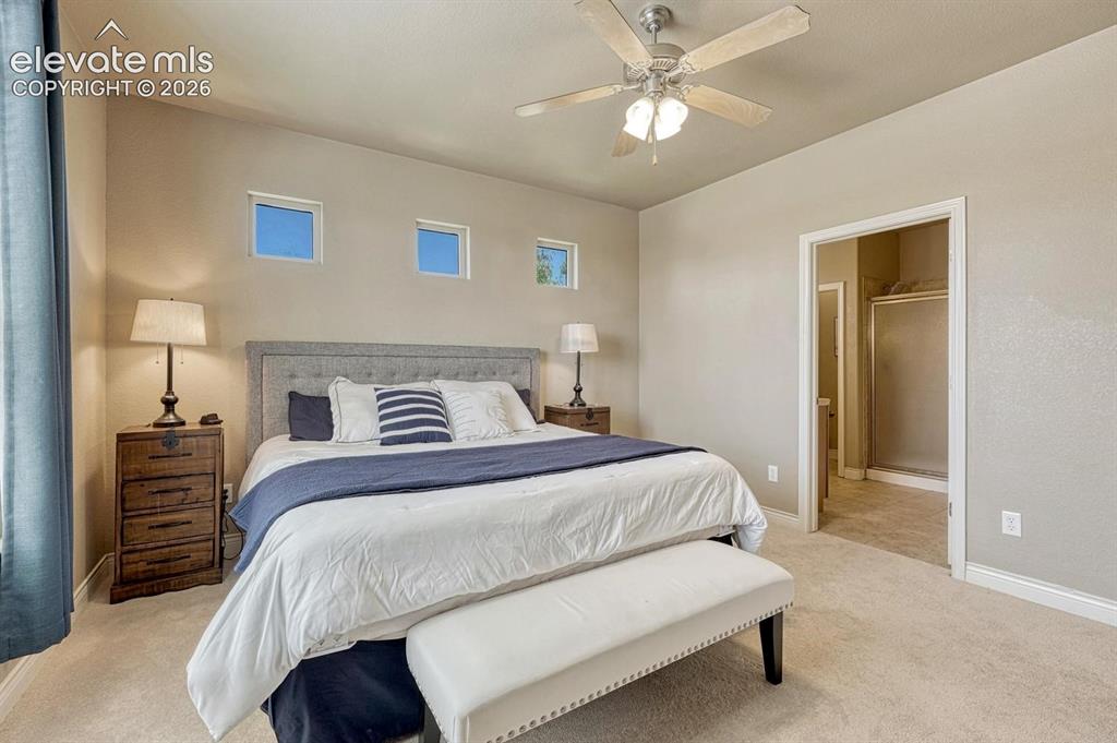 Image 21 of 41: Primary Bedroom with En Suite bath featuring a ceiling fan with light fixtu