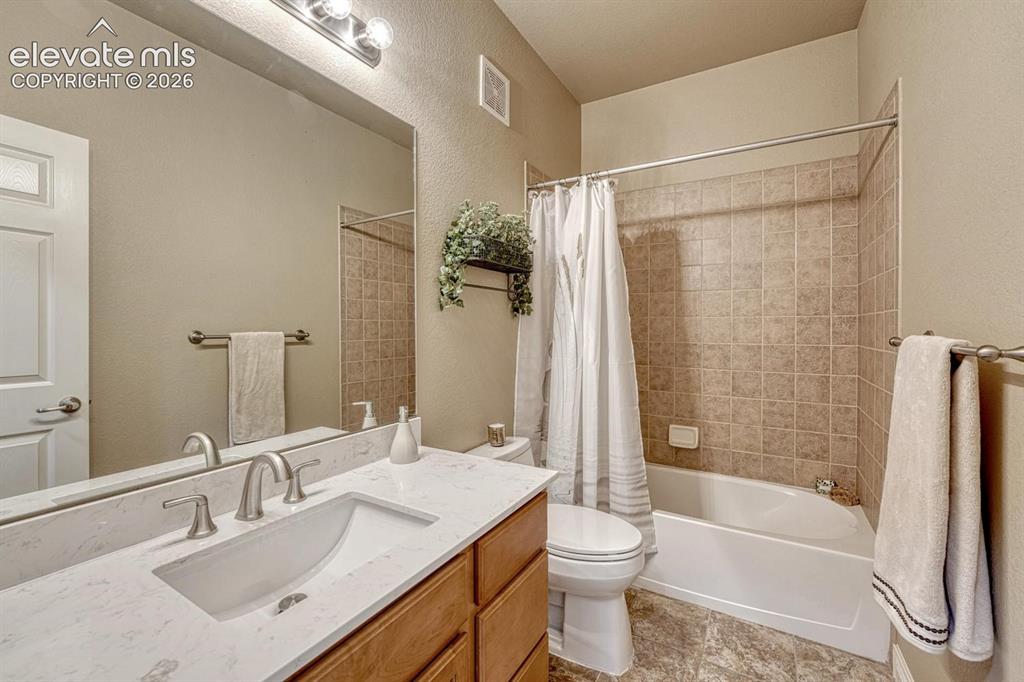 Image 27 of 41: 2nd Main Level Bathroom featuring a white bathtub with tiled surround, a va
