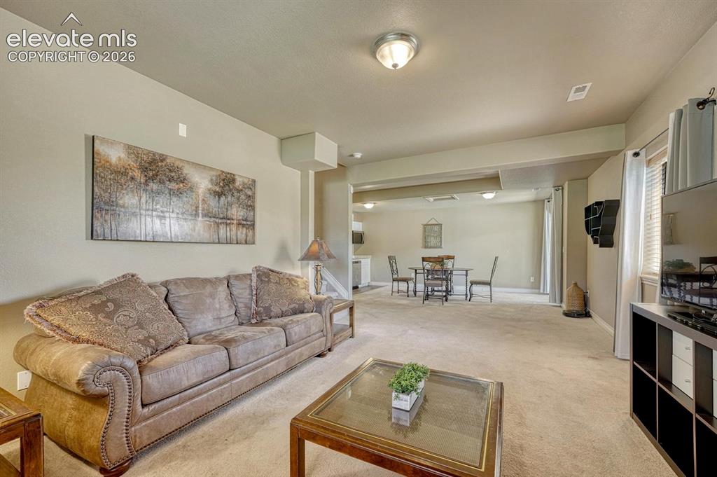 Image 30 of 41: Open-concept lower level family room featuring neutral-toned walls, recesse