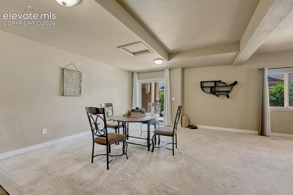 Image 33 of 41: Open-concept interior space featuring tray ceilings, neutral wall tones, an