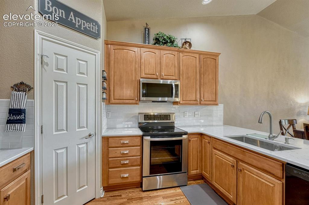 Image 7 of 41: Kitchen featuring wood cabinetry, stainless steel appliances, white subway