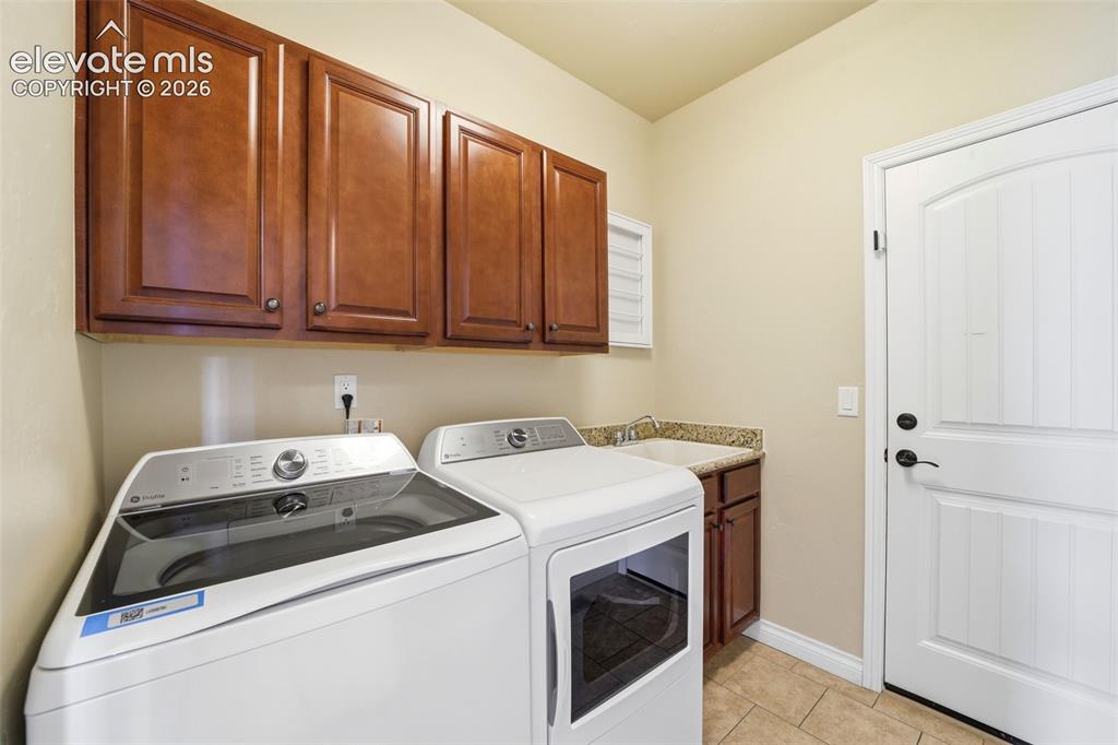 Image 25 of 50: Main Level laundry w/ sink and cabinets