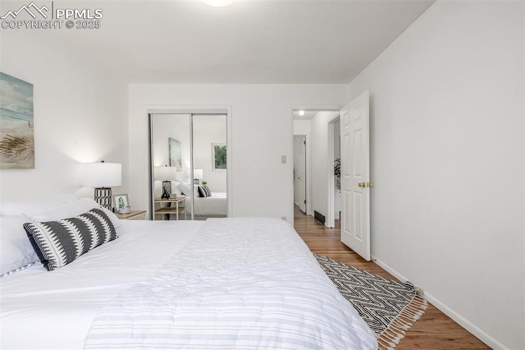 Image 10 of 36: Primary bedroom with newly refinished hardwood floors and gorgeous natural